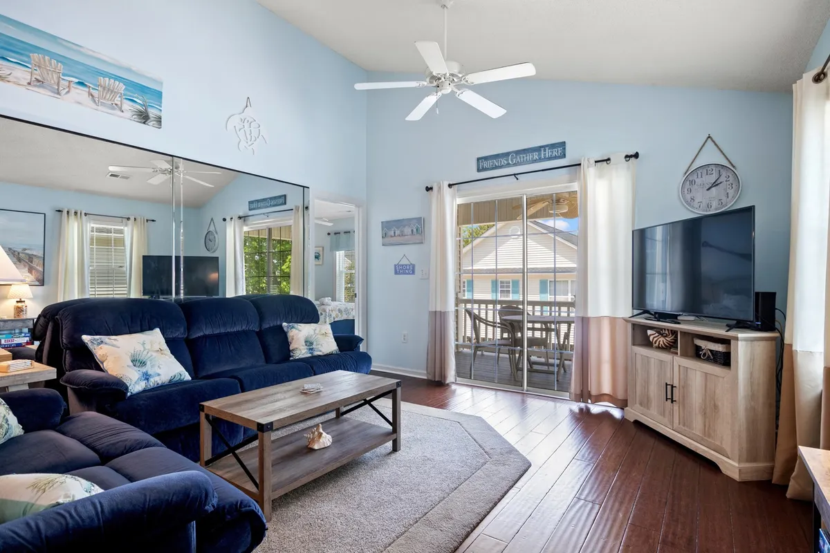 This scene focuses on a comfortable living area with a sofa, coffee table, television, and a window offering natural light. The setup invites guests to relax, watch TV, or enjoy quality time together, with the window view suggesting a bright and airy ambiance.